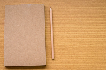 Note book with pencil on a wooden desk