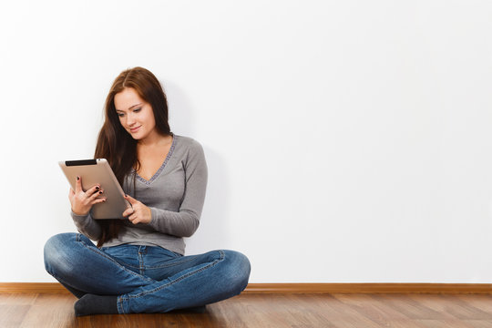 Beautiful Young Woman Sitting On Floor With Tablet