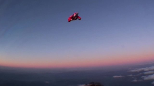 Skydiving Santa Claus jumping with a parachute at a sunset. Winter.