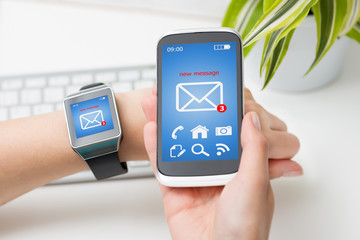 Female hands with smartwatch and phone with email.