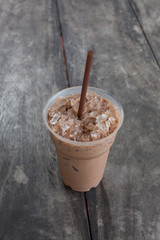 Cold coffee drink with ice on old wood table