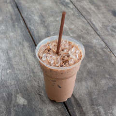 Cold coffee drink with ice on old wood table