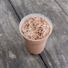 Cold coffee drink with ice on old wood table