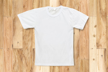 White blank T-shirt on wood texture background