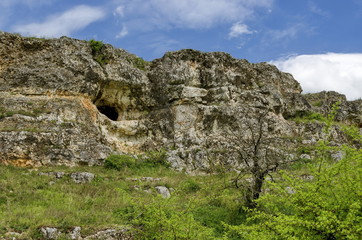 Fototapeta na wymiar General view toward sedimentary rock with cave in the field, Ludogorie, Bulgaria 