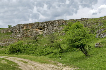 Fototapeta na wymiar General view toward sedimentary rock with cave in the field, Ludogorie, Bulgaria
