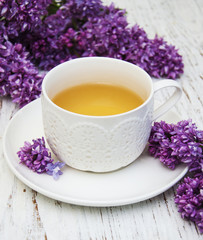 Cup of tea and lilac flowers