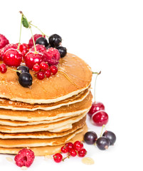 Stack of pancakes with berries and honey
