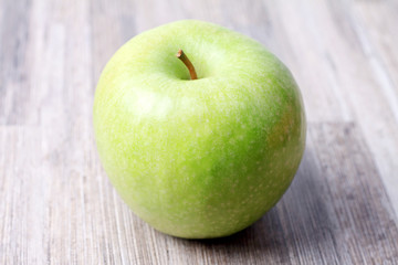 Green apple on wooden background