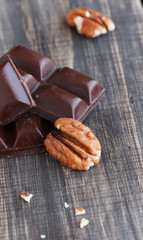 pieces of chocolate with walnuts lying on a wooden