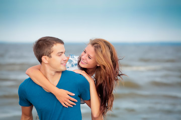 Fototapeta na wymiar Couple of a young lovers on the beach having dating