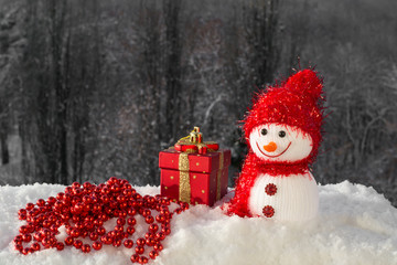 Christmas card with a cute snowman, Christmas toy and beads on snow 