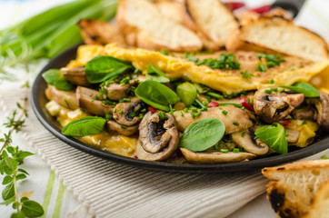 Omelet with mushrooms, lamb's lettuce, herbs and chilli