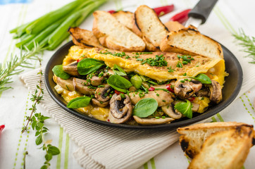 Omelet with mushrooms, lamb's lettuce, herbs and chilli