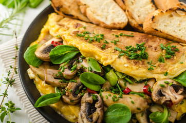 Omelet with mushrooms, lamb's lettuce, herbs and chilli