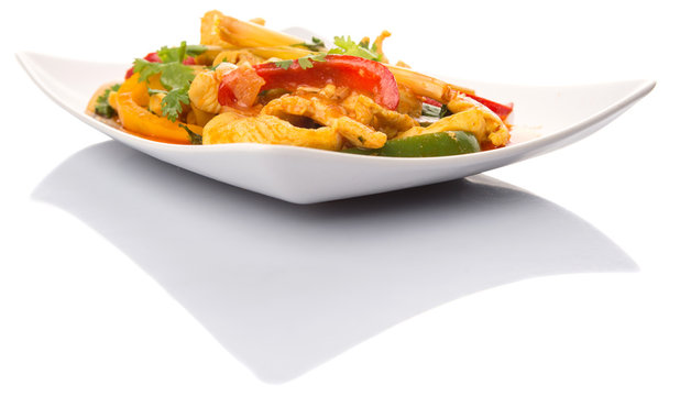Malaysian traditional dish of Ayam Paprik or spicy stir fry chicken on white plate over white background