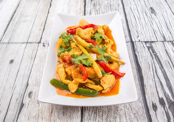  Malaysian traditional dish of Ayam Paprik or spicy stir fry chicken on white plate over wooden...