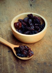 Heap of raisins on wood background