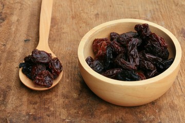 Heap of raisins on wood background