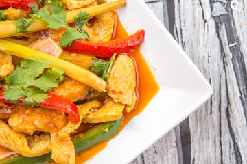  Malaysian traditional dish of Ayam Paprik or spicy stir fry chicken on white plate over wooden background