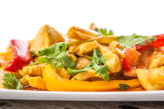  Malaysian traditional dish of Ayam Paprik or spicy stir fry chicken on white plate over wooden background