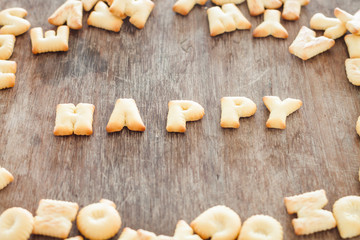 Happy alphabet biscuit on wooden table
