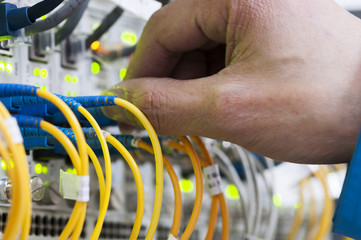 Man connecting network cables to switches