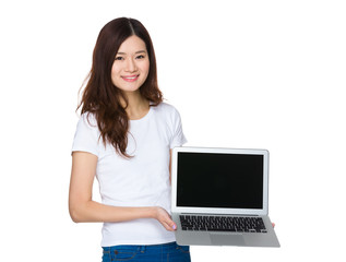 Young woman show with the blank screen of laptop computer