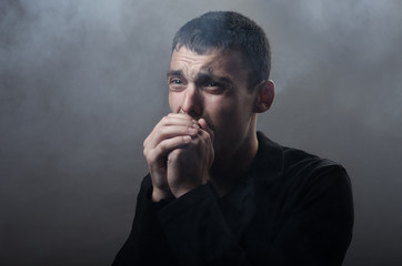 young man suffocating in the poisonous smoke