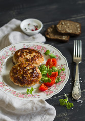 pork cutlet and fresh vegetable salad on a dark wooden background