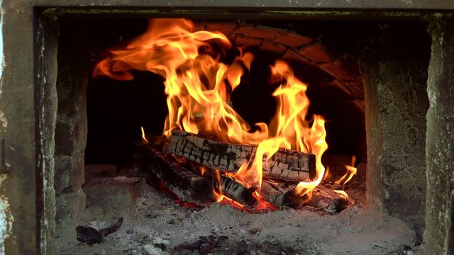 ULTRA HD 4K real time shot, Close up of flames burning wood. In a conventional stove, when wood is added to a hot fire, a process of pyrolysis or destructive distillation begins.