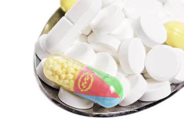 Spoon full of pills and a capsule with the flagdesign of Eritrea
