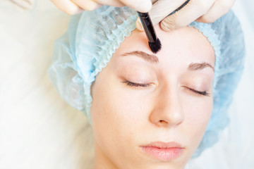 Professional woman at spa beauty salon doing correction eyebrow