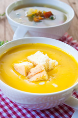 Pumpkin soup with croutons in white bowl