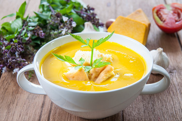 Pumpkin soup with croutons in white bowl
