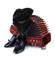 Bandoneon, black hat and tango shoes on white