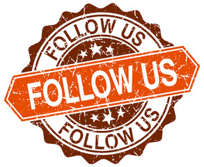 follow us orange round grunge stamp on white