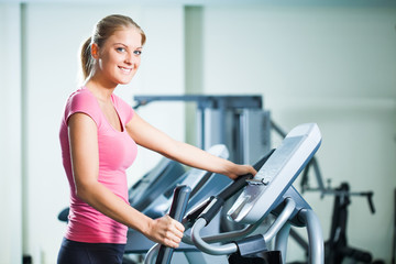 Fototapeta premium Woman exercising on treadmill in gym
