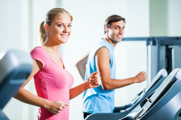Happy couple exercising in gym