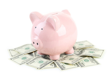 Pink piggy bank on dollars isolated on a white