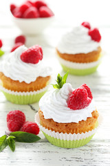 Raspberry cupcakes on white wooden background