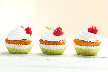 Raspberry cupcakes on white wooden background