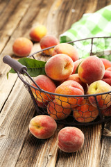 Ripe peaches fruit in basket on a brown wooden background