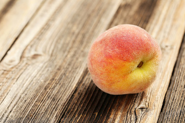 Ripe peach fruit on a brown wooden background