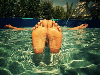 feet of a man in a swiming pool