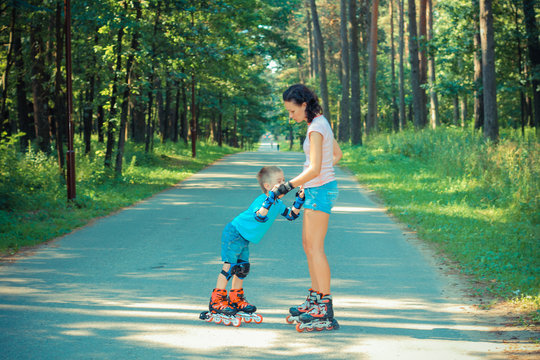 mother and son learn to roller skate. Mom with child having fun on roller skates