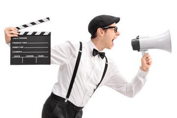 Naklejka premium Young movie director holding a clapperboard and shouting on a me