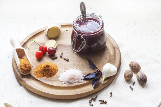 Cherry sauce, cherries and spices on a wooden board
