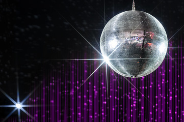 Disco ball with stars in nightclub with striped violet and black walls lit by spotlight 