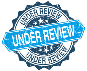 Fototapeta premium under review blue round grunge stamp on white